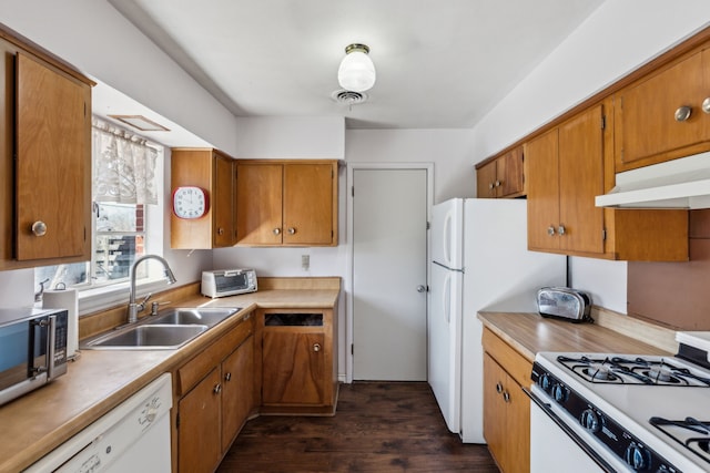 kitchen with brown cabinets, visible vents, a sink, white appliances, and under cabinet range hood