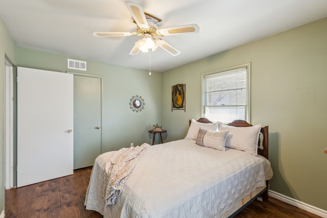 bedroom featuring visible vents, ceiling fan, baseboards, and wood finished floors