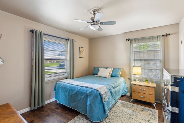 bedroom with ceiling fan, dark wood-style flooring, and baseboards