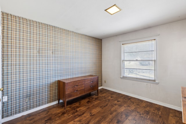 unfurnished room with wallpapered walls, baseboards, and wood finished floors