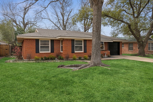 ranch-style home featuring driveway, a garage, a front yard, and brick siding