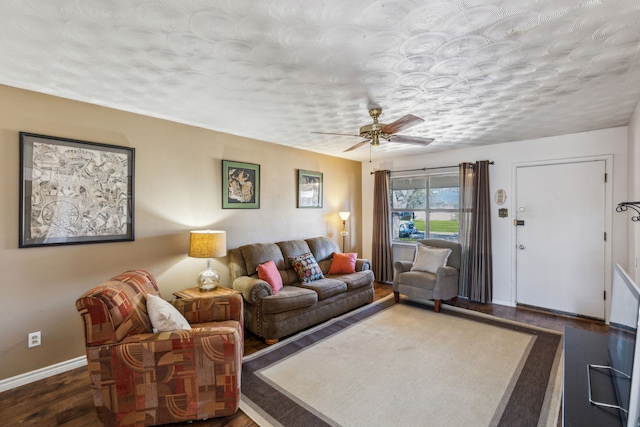 living room with a textured ceiling, wood finished floors, a ceiling fan, and baseboards