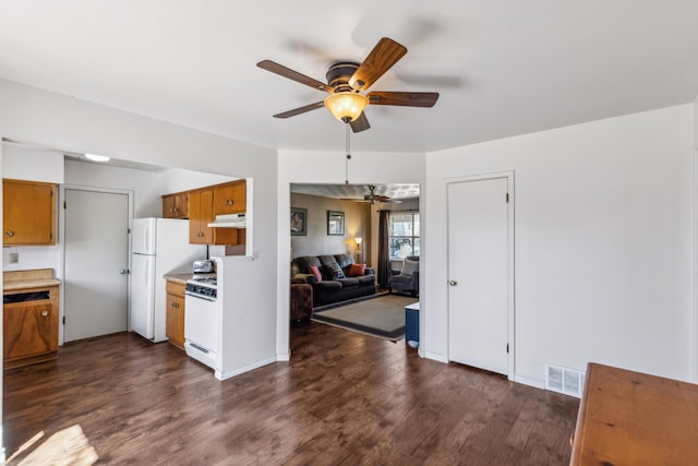 kitchen with under cabinet range hood, white appliances, dark wood-style flooring, visible vents, and light countertops