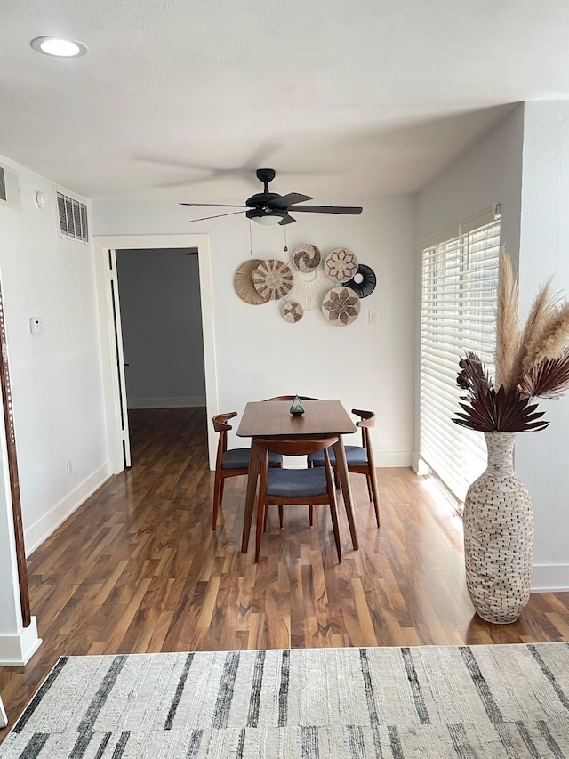 dining space featuring wood finished floors, visible vents, and baseboards