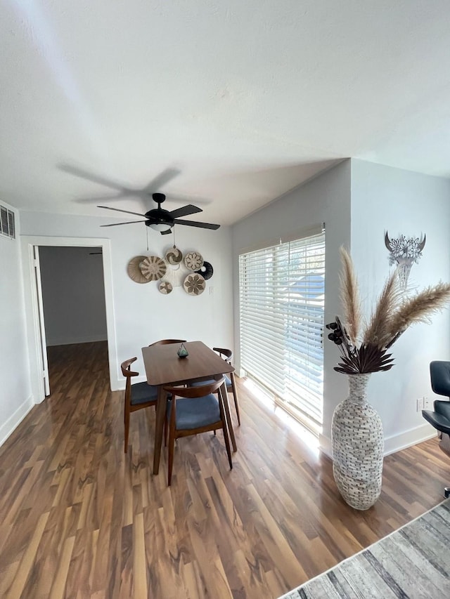 dining room featuring ceiling fan, wood finished floors, visible vents, and baseboards