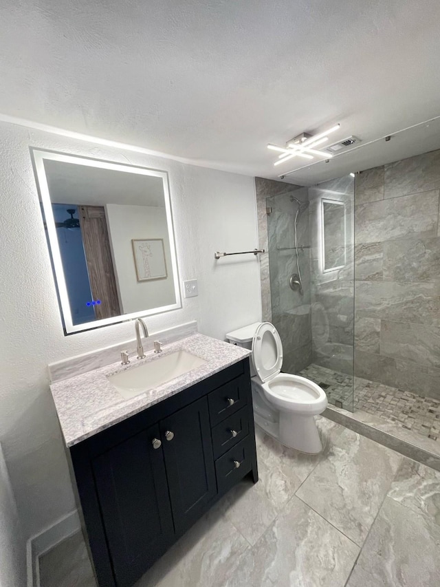 full bath featuring visible vents, tiled shower, toilet, marble finish floor, and vanity