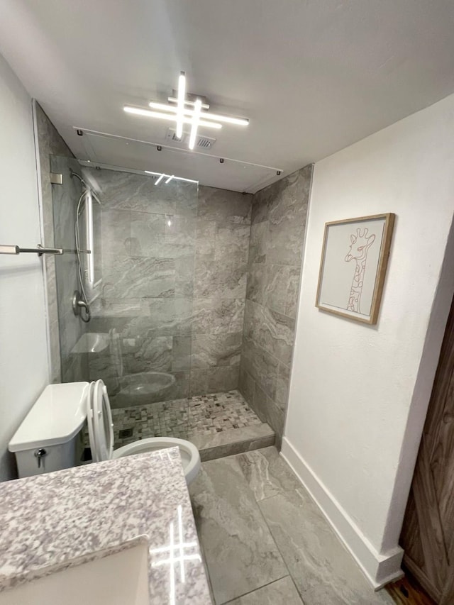 full bath featuring a stall shower, baseboards, toilet, marble finish floor, and vanity