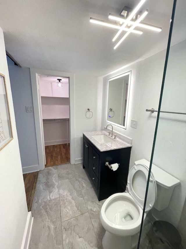 bathroom featuring toilet, vanity, and baseboards