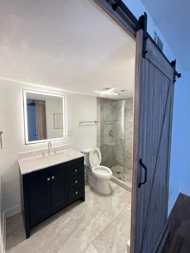 bathroom with a stall shower, vanity, toilet, and baseboards