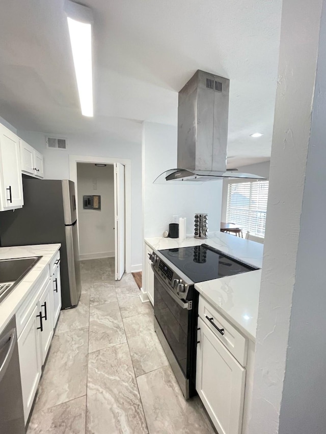 kitchen featuring marble finish floor, island exhaust hood, stainless steel appliances, visible vents, and white cabinetry