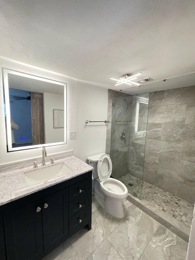 bathroom with toilet, marble finish floor, a walk in shower, and vanity