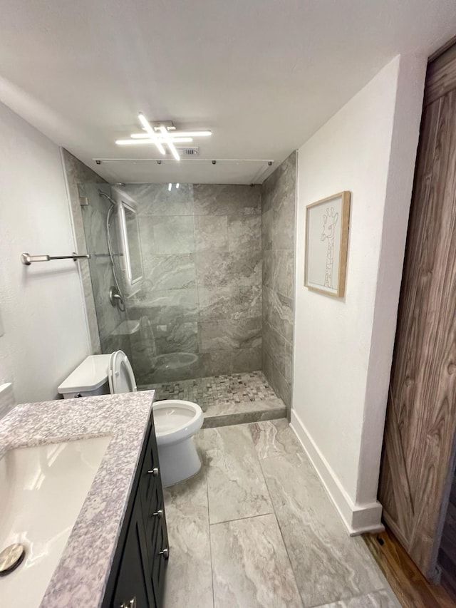 full bath with toilet, baseboards, tiled shower, and vanity