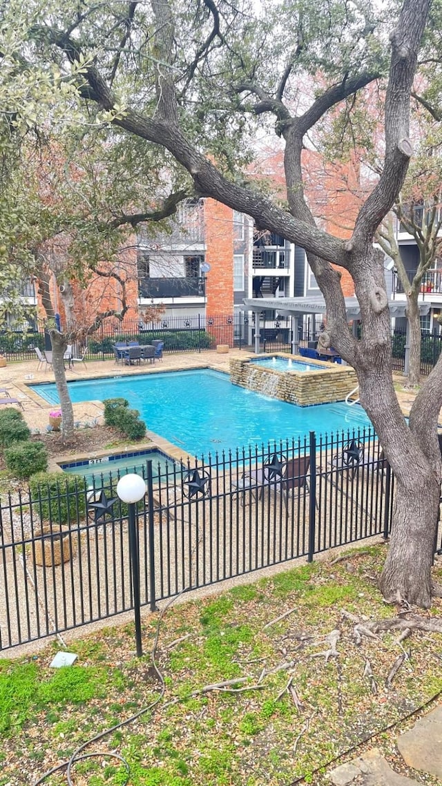 pool with a patio area and fence