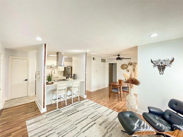 18333 Roehampton Dr Unit 123, Dallas, TX 75252 - kitchen featuring stainless steel appliances, island exhaust hood, a sink, backsplash, and white cabinetry