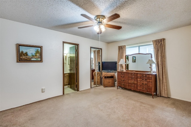 bedroom with light carpet, ceiling fan, and a textured ceiling