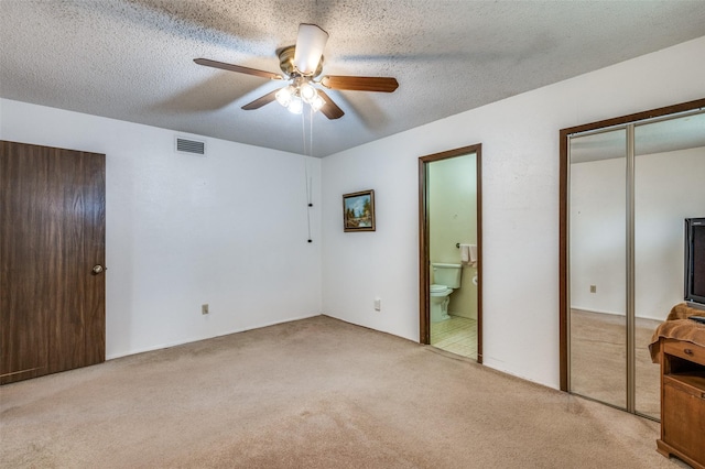 unfurnished bedroom featuring carpet, a closet, visible vents, and a textured ceiling