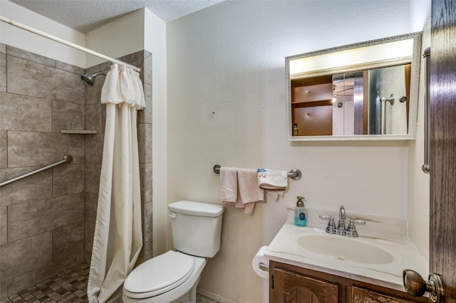 bathroom featuring tiled shower, vanity, toilet, and a textured ceiling