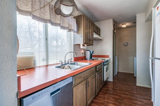 kitchen with dishwasher, dark wood-style floors, a textured ceiling, a sink, and range with electric stovetop