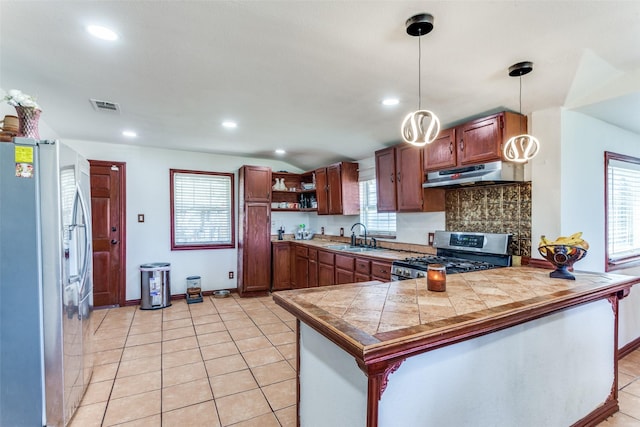 kitchen with visible vents, a peninsula, stainless steel appliances, under cabinet range hood, and a sink