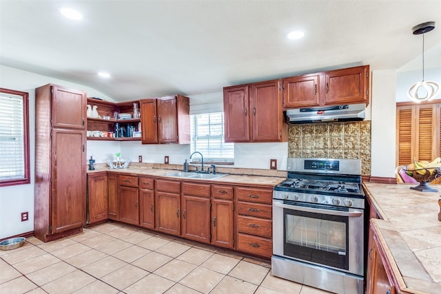 kitchen featuring tile countertops, under cabinet range hood, a sink, stainless steel gas stove, and open shelves