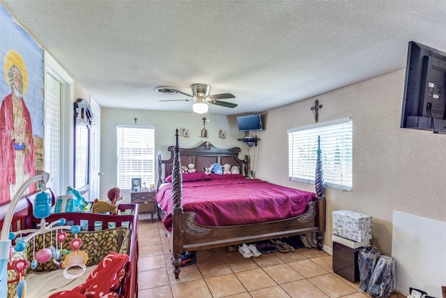 tiled bedroom featuring ceiling fan, a textured ceiling, and visible vents