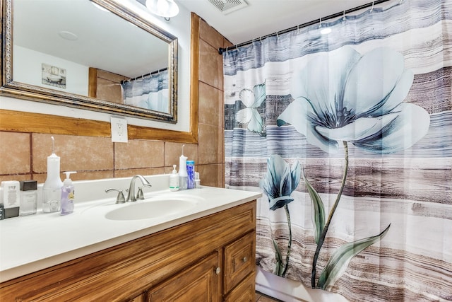 bathroom featuring tasteful backsplash, tile walls, visible vents, and vanity