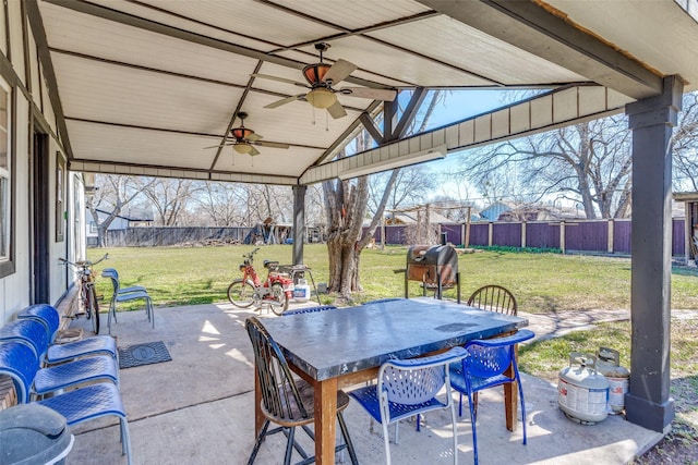 view of patio featuring ceiling fan, outdoor dining area, and a fenced backyard