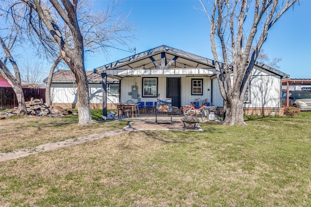 view of front of property featuring an outbuilding, fence, a front yard, a shed, and a patio area