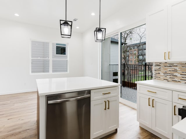 kitchen with tasteful backsplash, decorative light fixtures, dishwasher, light countertops, and light wood-type flooring