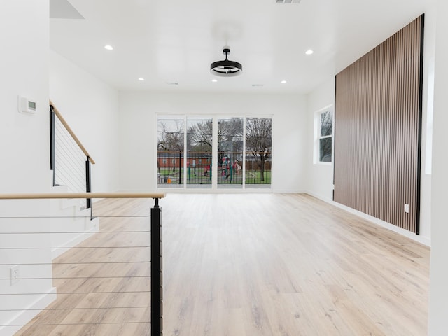 unfurnished living room with recessed lighting, wood finished floors, visible vents, and baseboards