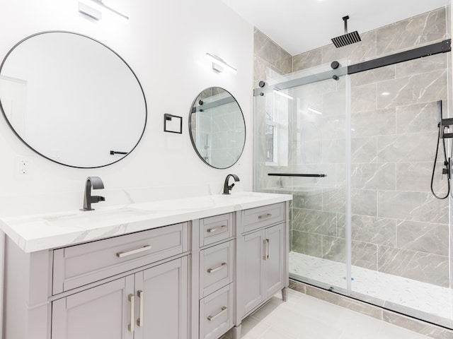 bathroom with double vanity, a stall shower, and a sink