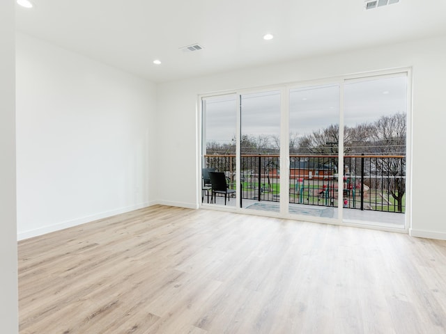 empty room featuring visible vents, recessed lighting, baseboards, and wood finished floors