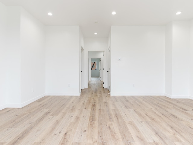 unfurnished room featuring recessed lighting, light wood-type flooring, and baseboards