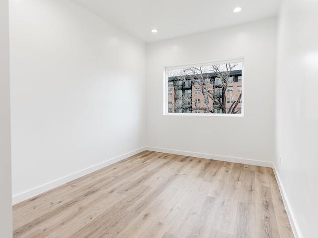 spare room with recessed lighting, baseboards, and wood finished floors