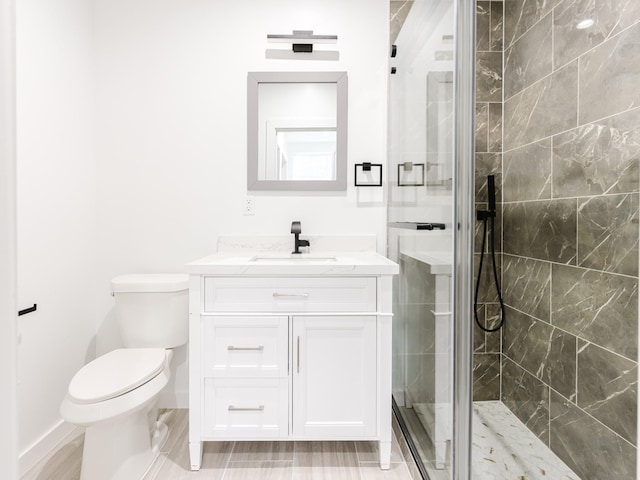 full bath featuring baseboards, toilet, a shower stall, and vanity