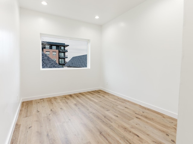 empty room featuring recessed lighting, baseboards, and wood finished floors