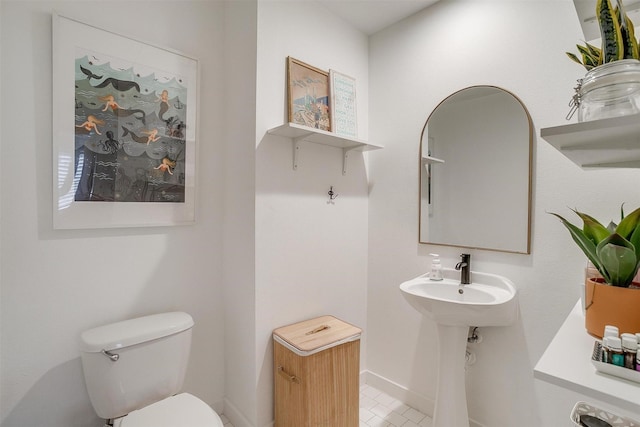 bathroom featuring toilet and baseboards