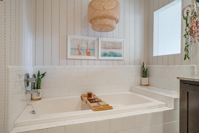 bathroom featuring wallpapered walls and a bath