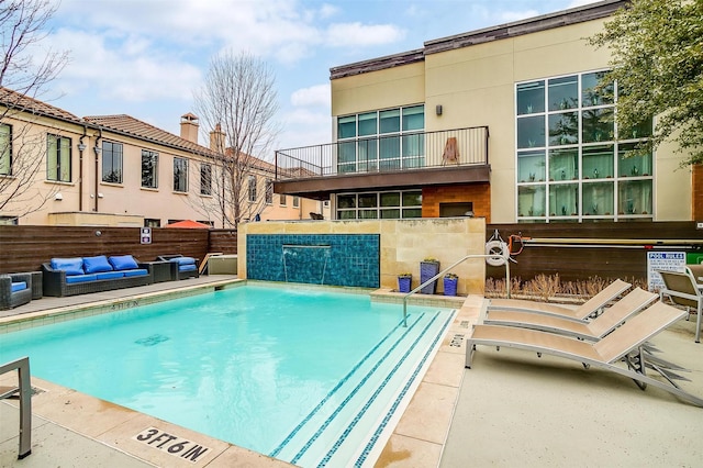 community pool with an outdoor hangout area, a patio area, and fence