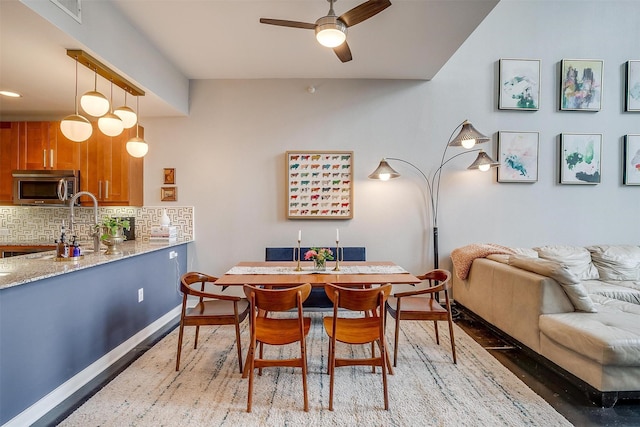 dining room with a ceiling fan, light wood-type flooring, and baseboards