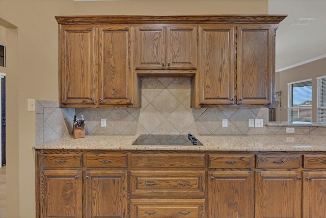 kitchen with visible vents, black electric cooktop, backsplash, and ornamental molding