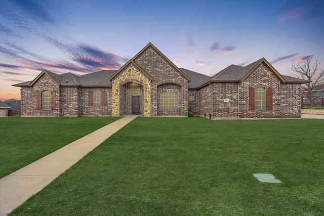 view of front of property featuring a front lawn and brick siding