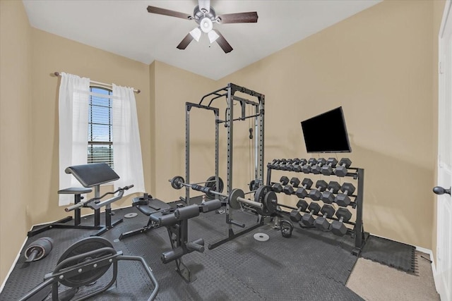 exercise room with a ceiling fan and baseboards