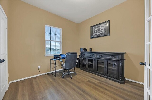 home office featuring baseboards and wood finished floors