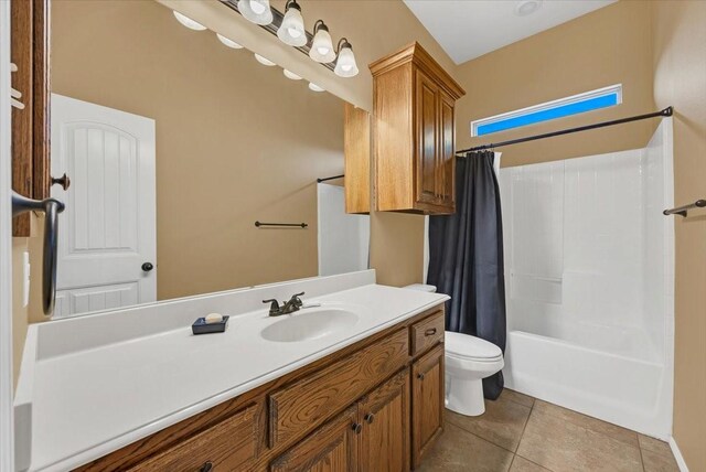 bathroom featuring shower / bathtub combination with curtain, vanity, toilet, and tile patterned floors