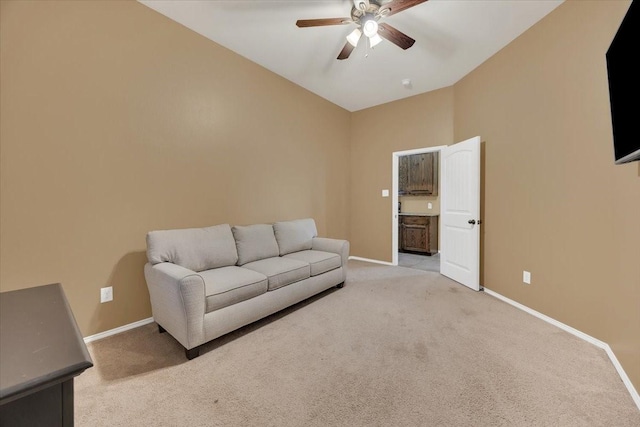 living room featuring baseboards, vaulted ceiling, a ceiling fan, and light colored carpet