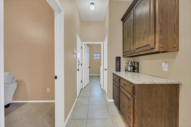 hall with baseboards and light tile patterned floors