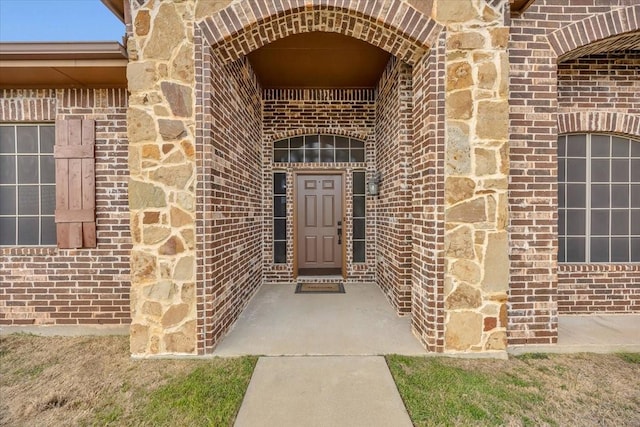 view of exterior entry with brick siding