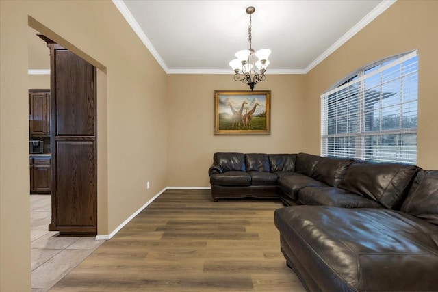 living room featuring light wood-style floors, a notable chandelier, crown molding, and baseboards