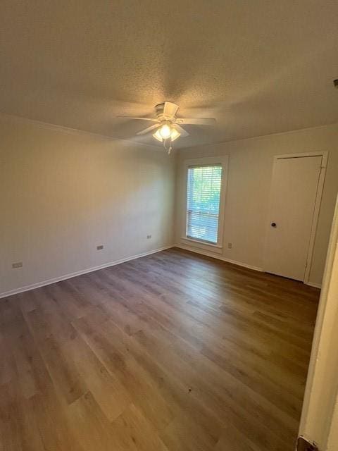 spare room with a textured ceiling, ceiling fan, and wood finished floors